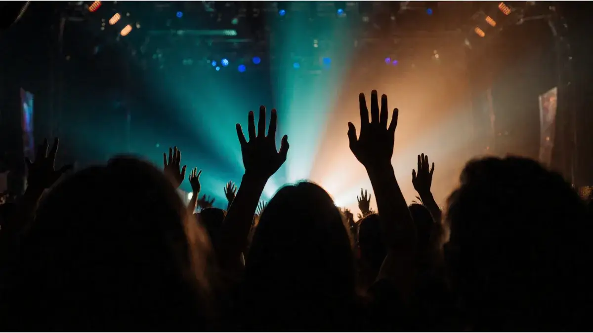 AI-generated illustration Concert crowd with raised hands in the stage lights — AI-generated illustration
