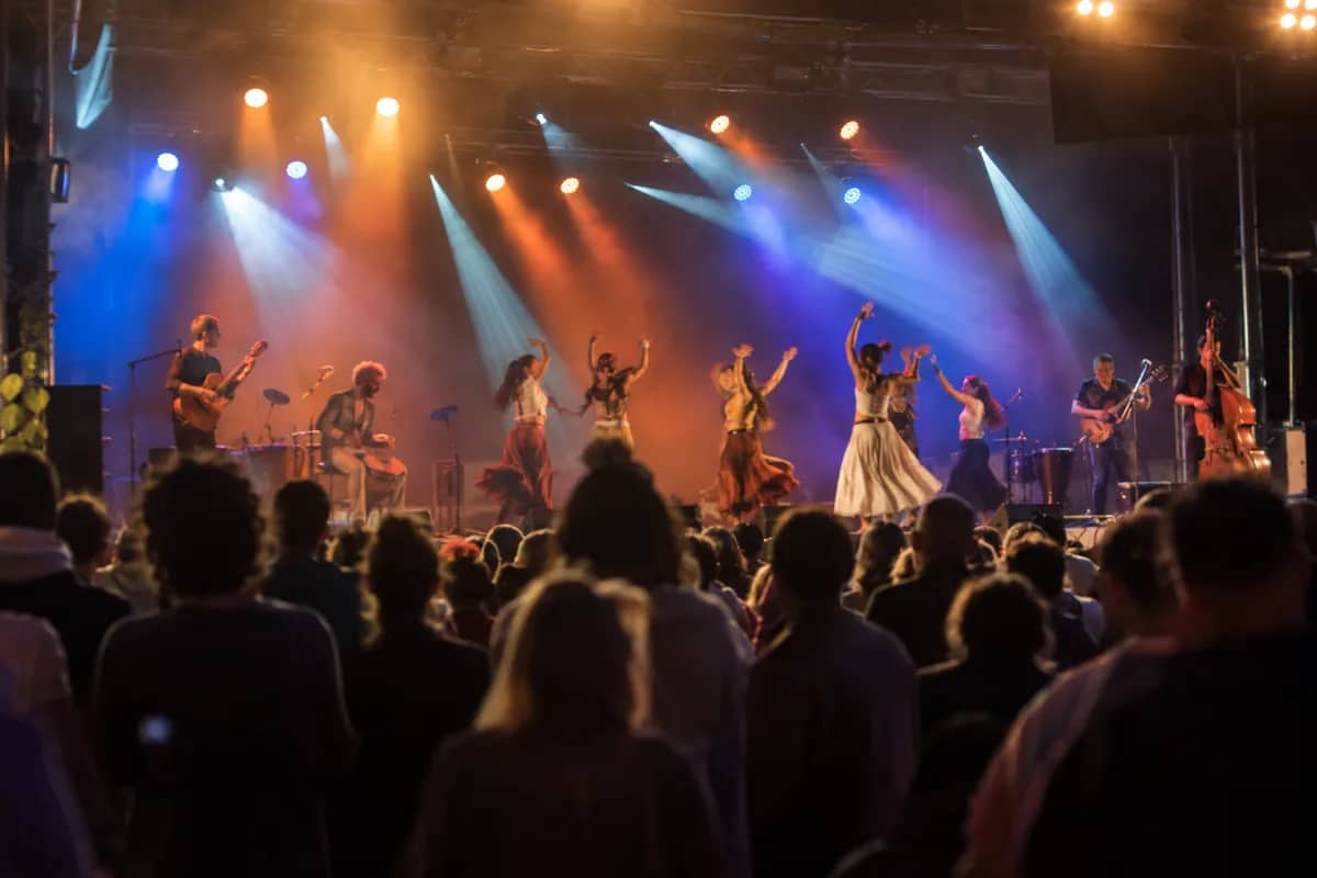 AI-generated illustration Colourful stage show with dancers and musicians in front of an audience — AI-generated illustration