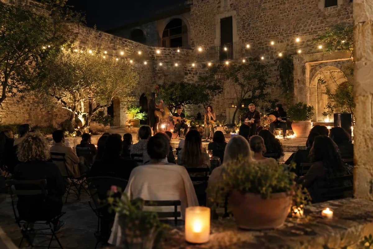 AI-generated illustration Evening concert in a stone courtyard with string lights and candles — AI-generated illustration