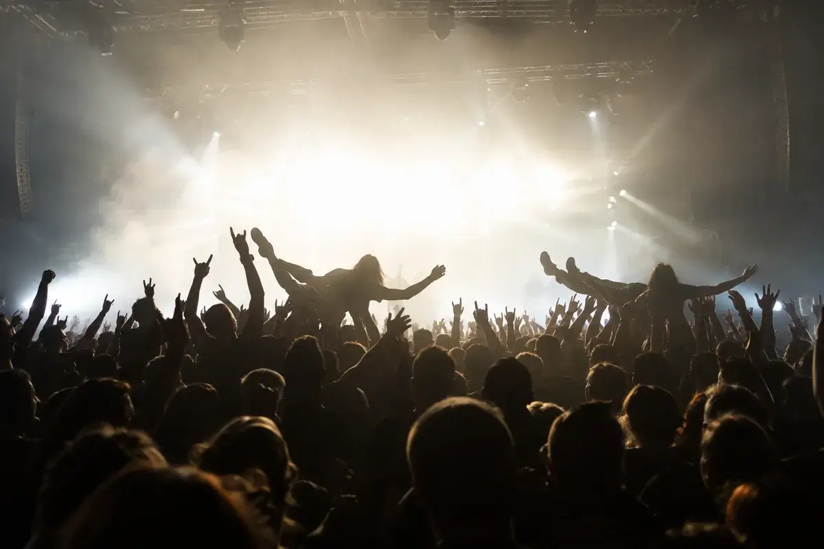 AI-generated illustration Festival crowd with raised arms in front of bright stage lights — AI-generated illustration